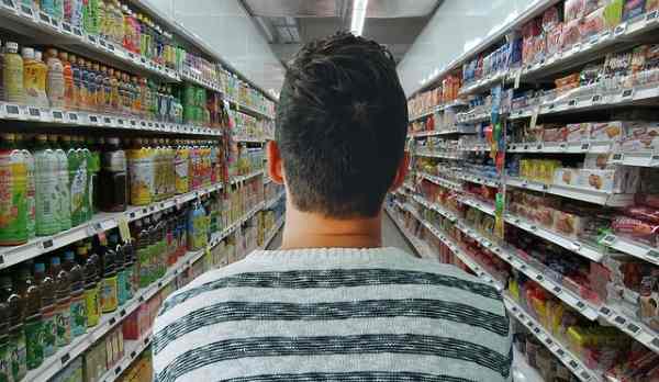 A man is entering an aisle in the grocery store.